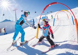 An instructor helping a kid during the Kids Ski Lessons (4-9 y.) for Beginners with Kronschool Valdaora.