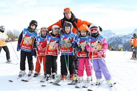 Kinderen gaan op de foto met de skileraar in Falcade na een van de Kinderskilessen (4-12 jaar) voor alle niveaus.