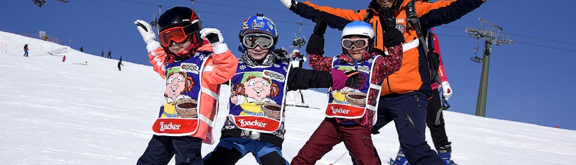Kinder und Skilehrer machen ein lustiges Foto in Falcade nach einem der Kinderskikurse "Mini Group" (4-12 J.) für alle Levels.