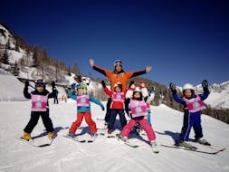 Kids having fun with the ski instructor in Falcade after one of the Kids Ski Lessons "Mini Group" (4-12 y.) of All Levels.