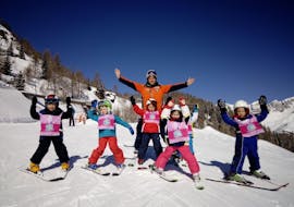 Kids having fun with the ski instructor in Falcade after one of the Kids Ski Lessons "Mini Group" (4-12 y.) of All Levels.