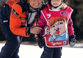 Kid and ski instructor smiling in Falcade during one of the Kids Ski Lessons (3-6 y.) for First Timers.