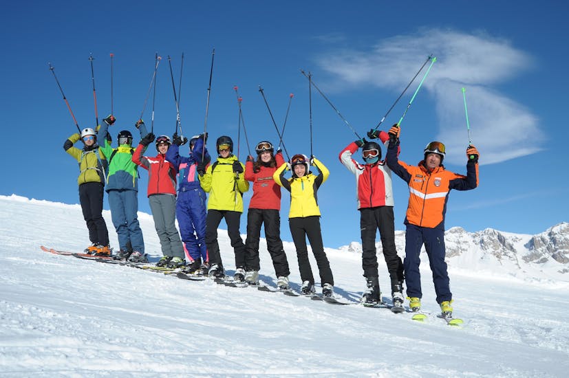 Blije deelnemers in Falcade tijdens een van de skilessen voor volwassenen voor alle niveaus.