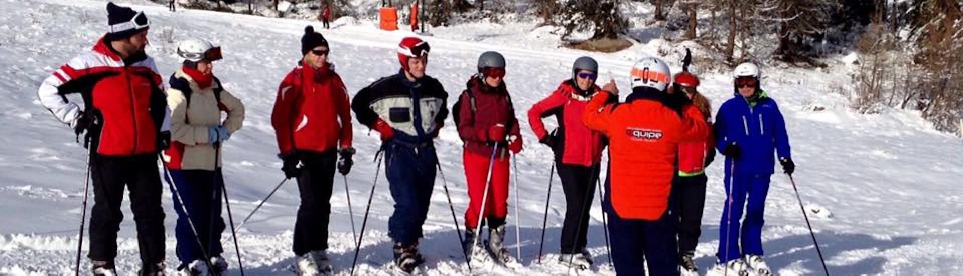 Adulti con maestro di sci a Falcade durante una delle Lezioni di Sci "Mini Gruppo" per Adulti di tutti i livelli.