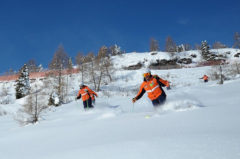 Skiers on fresh snow in Falcade during one of the Private Off-Piste Skiing Lessons for All Levels.