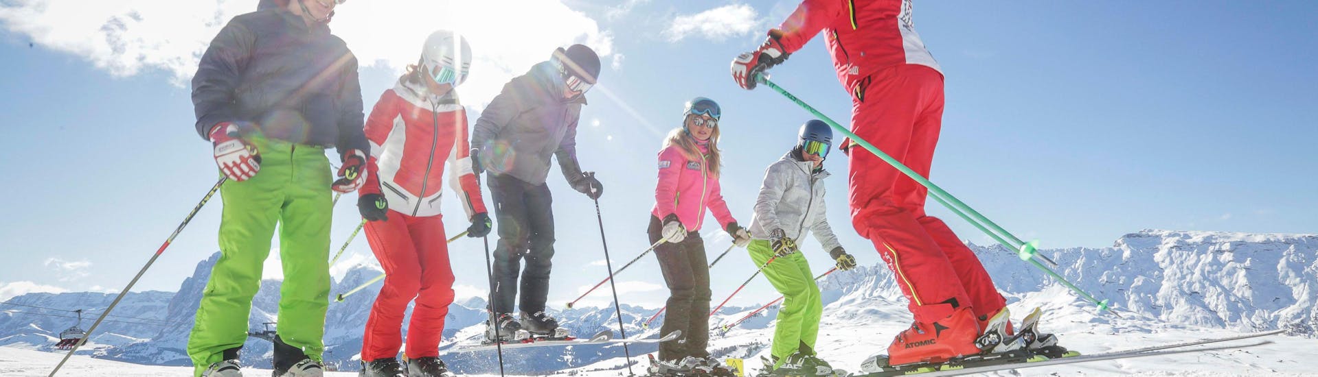 Een groep mensen heeft plezier tijdens een dag skiën met Scuola di Sci Alpe di Siusi. 