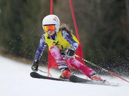 Ein erfahrenes Kind fährt die Piste am Semmering während des Kinder-Skikurses (5-17 J.) für alle Könnerstufen - Ganztag mit der Skischule Semmering hinunter.