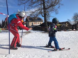 Ein Kind beim Skifahren mit Hilfe seines Skilehrers während des privaten Skikurses für Kinder (3-17 Jahre) aller Niveaus mit der Skischule Semmering.