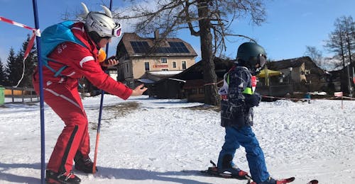 Privé Skilessen voor Kinderen (3-17 jaar) van Alle Niveaus met Skischule Semmering Een kind skiet met de hulp van zijn skileraar tijdens privé-skilessen voor kinderen (3-17 j.) van alle niveaus bij Skischule Semmering.