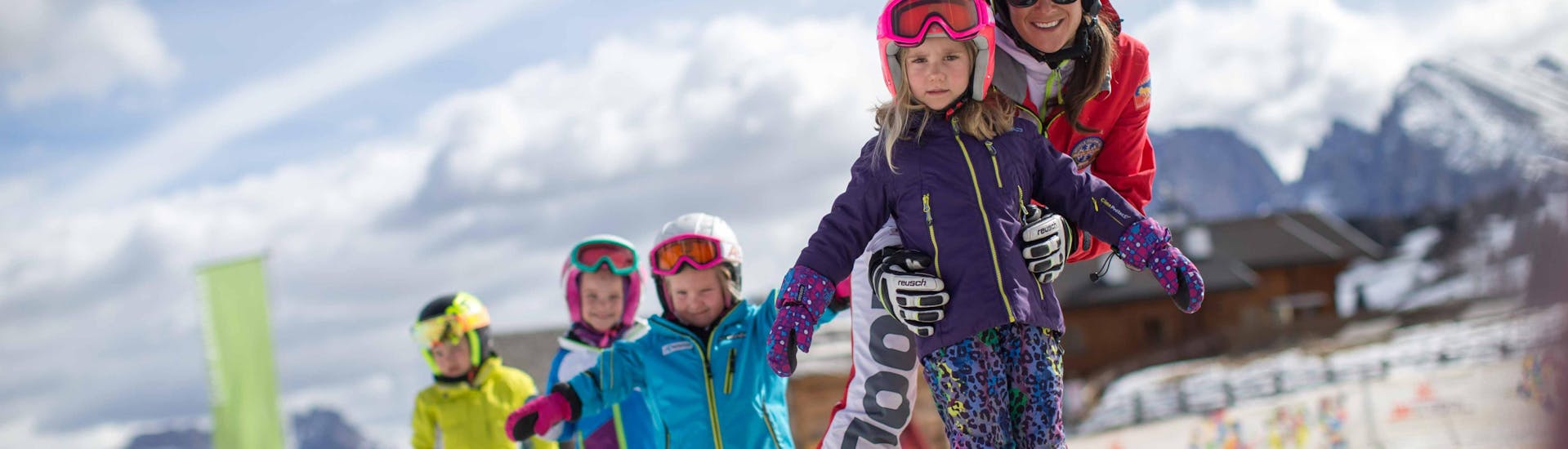 Persone che si divertono sulla neve durante le lezioni di sci per bambini per intermedi con la Scuola di Sci Alpe di Siusi.