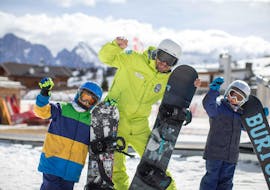 Happy kids with their instructor during the private snowboarding lesson with Scuola Sci Alpe di Siusi.