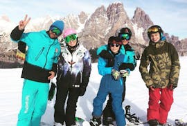 Un groupe d'amis et leur moniteur de la Scuola di Snowboard Boarderline pendant les cours de snowboard pour enfants et adultes - tous niveaux.