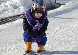 Kids Ski Lessons (4-5 y.) "Minis" for First Timers from Skischule Stubai Tirol A boy is gliding down a slope in the Kinderland during his Ski Lessons for Kids "Tiny Tots" with Skischool Mayrhofen in Stubai.