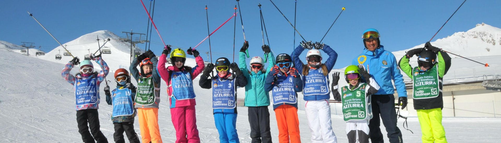Eine Gruppe Kinder hat bei ihrem Kinder Skikurs (4-14 J.) - Halbtags - Ohne Erfahrung mit der Skischule Scuola di Sci Azzurra Livigno großen Spaß auf den Skipisten von Livigno.