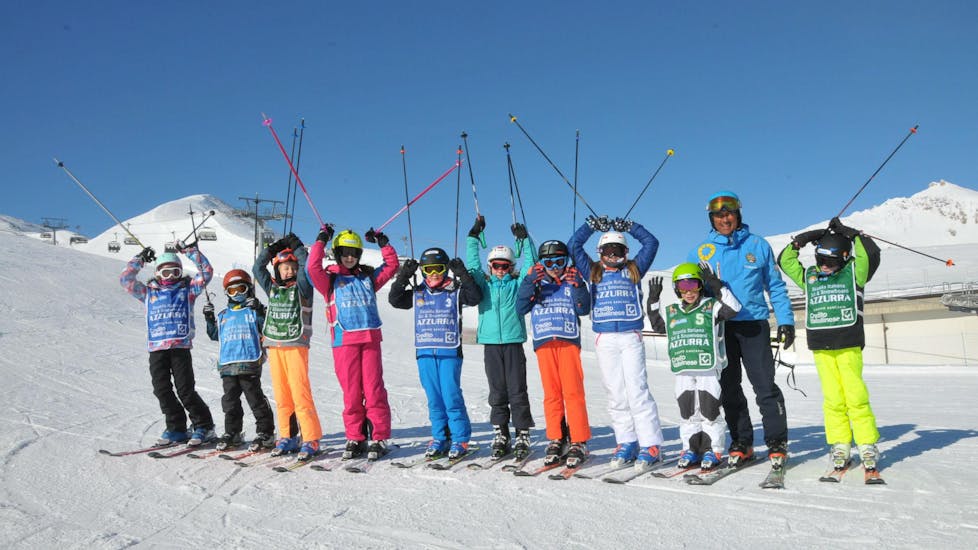 Eine Gruppe Kinder hat bei ihrem Kinder Skikurs (4-14 J.) - Ganztags mit der Skischule Scuola di Sci Azzurra Livigno großen Spaß auf den Skipisten von Livigno.