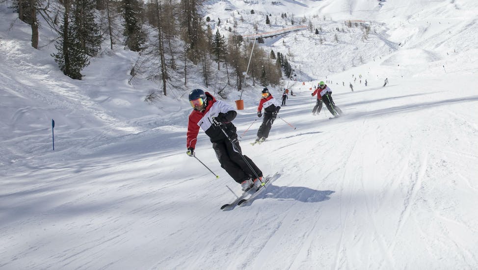 Skiërs racen de piste af tijdens de volwassen skilessen voor gevorderden in Stubai.