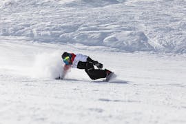 Uno snowboarder scende da un pendio durante le sue lezioni private di snowboard per tutti i livelli a Stubai con Skischule Stubai Tirol.
