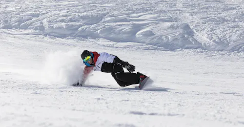 Private Snowboarding Lessons for All Levels with Skischule Stubai Tirol A snowboarding is riding down a slope during his private snowboarding lessons for all levels in Stubai with Skischule Stubai Tirol..