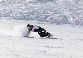 Uno snowboarder scende da un pendio durante le sue lezioni private di snowboard per tutti i livelli a Stubai con Skischule Stubai Tirol.