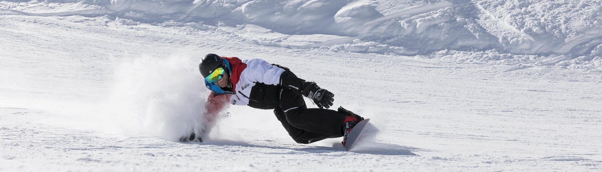 Private Snowboarding Lessons for All Levels with Skischule Stubai Tirol A snowboarding is riding down a slope during his private snowboarding lessons for all levels in Stubai with Skischule Stubai Tirol..