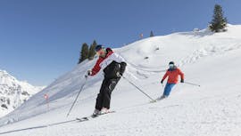 Twee skiërs rijden van een berg af tijdens hun privé skilessen voor volwassenen van alle niveaus in Stubai.