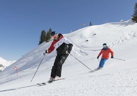 Two skiers riding down a mountain during their private ski lessons for adults of all levels in Stubai.