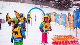 Kleine Kinder beim Üben während ihres privaten Skikurses für Kleinkinder (1-3 Jahre) Anfänger mit der Skischule Yellow Point Špindlerův Mlýn.