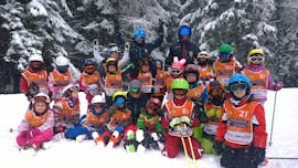 Een grote groep kinderen geniet van hun kinderskilessen bij de skischool van Pontedilegno.