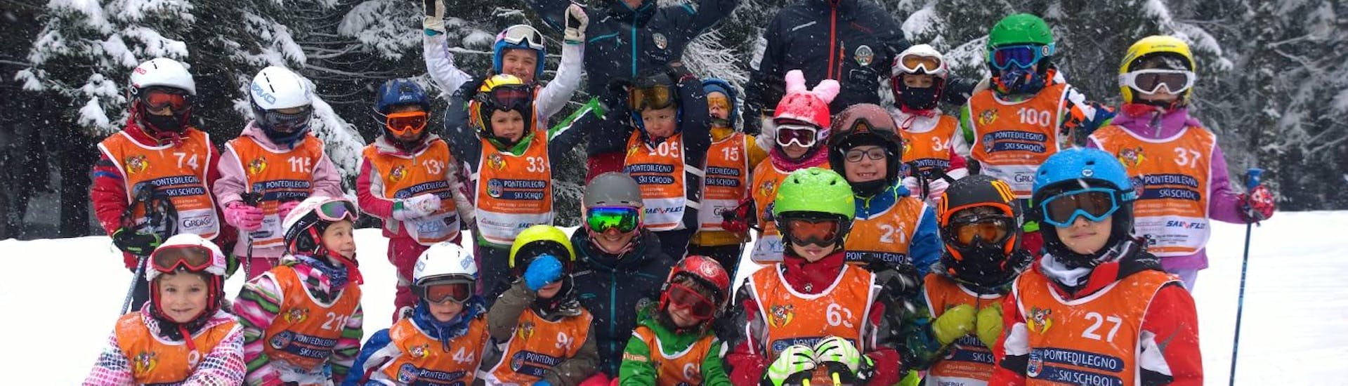 Eine große Gruppe von Kindern genießt ihren Kinder-Skikurs mit der Skischule Pontedilegno.