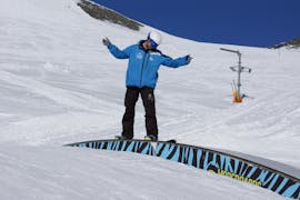 Een snowboarder leert in het funpark tijdens privé-snowboardlessen bij skischool Neustift Olympia op de Stubaier gletsjer wat kunstjes.