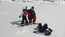 Zwei Kinder haben Spaß beim Snowboardunterricht mit der Skischule Pontedilegno.