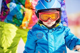 Un petit enfant apprend à skier pendant les cours particuliers de ski pour enfants avec l'école de ski de Pontedilegno.