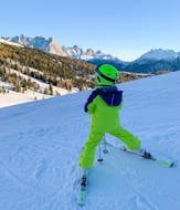 Ein Kind genießt während einem der privaten Skikurse für Kinder für alle Niveaus die Aussicht auf die Berge in Predazzo.