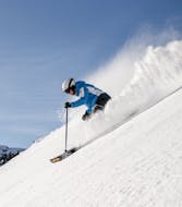 Maestro di sci in flessione sulle piste prima di una delle lezioni private di sci per adulti di tutti i livelli a Predazzo.