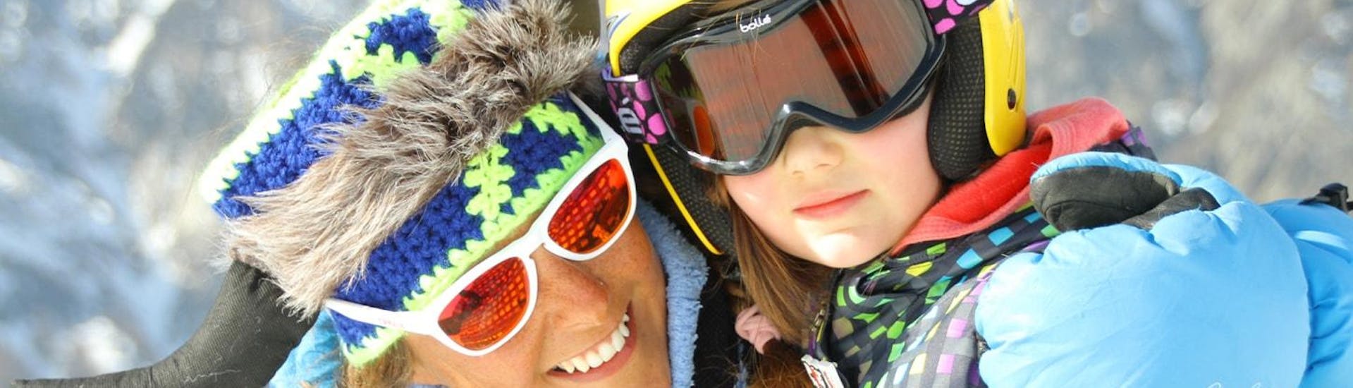 Happy moments of a little skier with her ski instructor from the ski school Scuola di Sci Bardonecchia during the Kids Ski Lessons (4-14 y.) - High Season - Beginner.