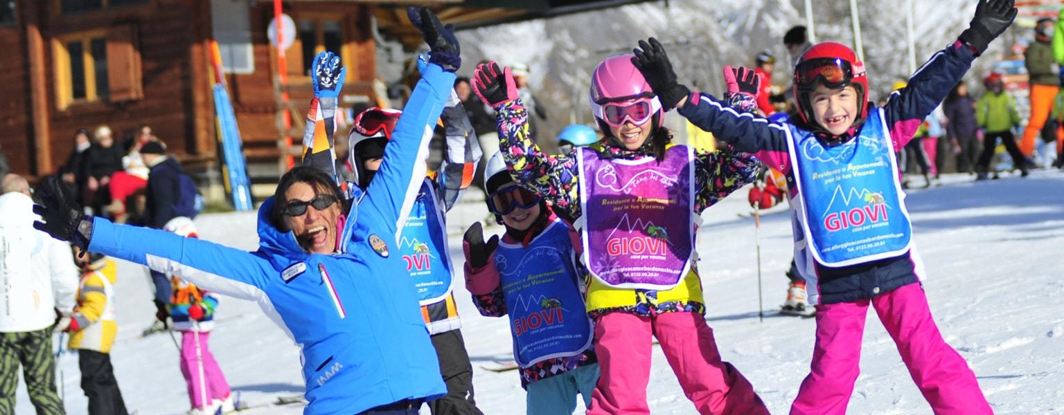 Kids are playing games and learn how to ski with their new friends in the Kids Ski Lessons (4-14 y.) - Low Season - Advanced under the supervision of an experienced ski instructor from the ski school Scuola di Sci Bardonecchia.