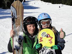 An instructor and child are smiling during snowboarding lessons for kids and adults with experience with skischool Oberharz in Wurmberg.