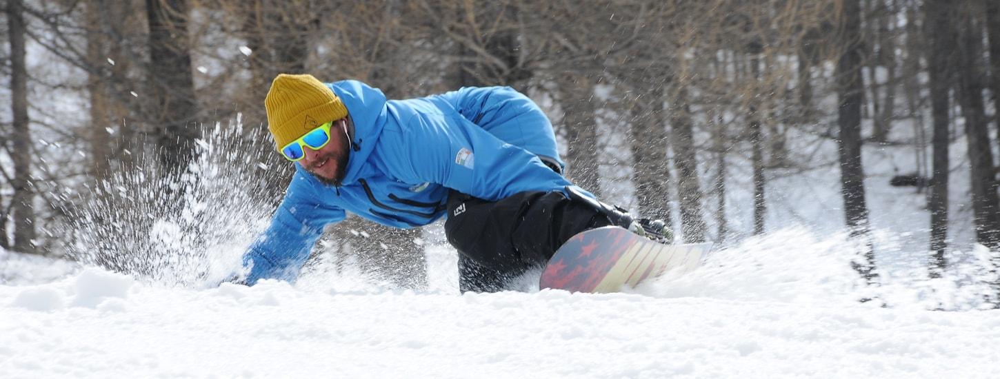 A young snowboarder is mastering his turns during the Snowboarding Lessons for Kids & Adults - Low Season in the ski school Scuola di Sci Bardonecchia.