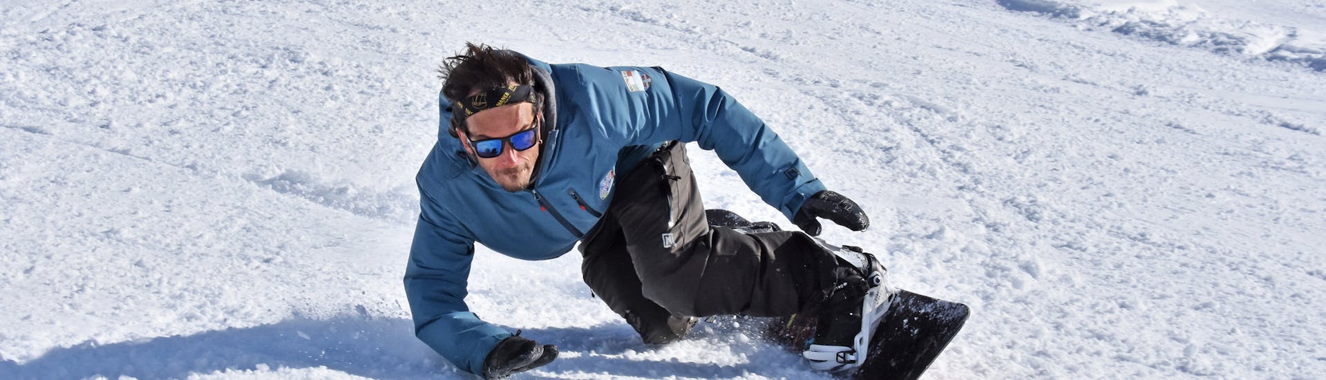 A snowboard instructor is training in Bardonecchia for one of the private snowboarding lessons for kids and adults of all levels.