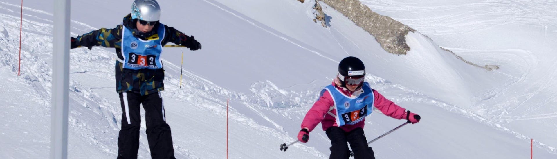 Due bambini che si godono le loro lezioni private di sci per bambini di tutti i livelli con l'École de Ski 333.