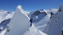 Ein Freerider steht auf dem Gipfel eines Berges während seines privaten Freeride-Kurses mit der Skischule 333 in Tignes.