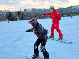 Ein Snowboarder lernt, sein Gleichgewicht zu finden, während des Snowboard-Privatunterrichts für Kinder und Erwachsene aller Levels mit der Premiere Ski School Vysoké Tatry.