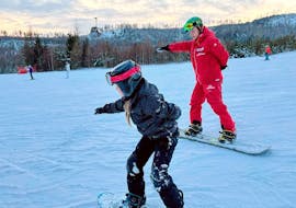 Ein Snowboarder lernt, sein Gleichgewicht zu finden, während des Snowboard-Privatunterrichts für Kinder und Erwachsene aller Levels mit der Premiere Ski School Vysoké Tatry.
