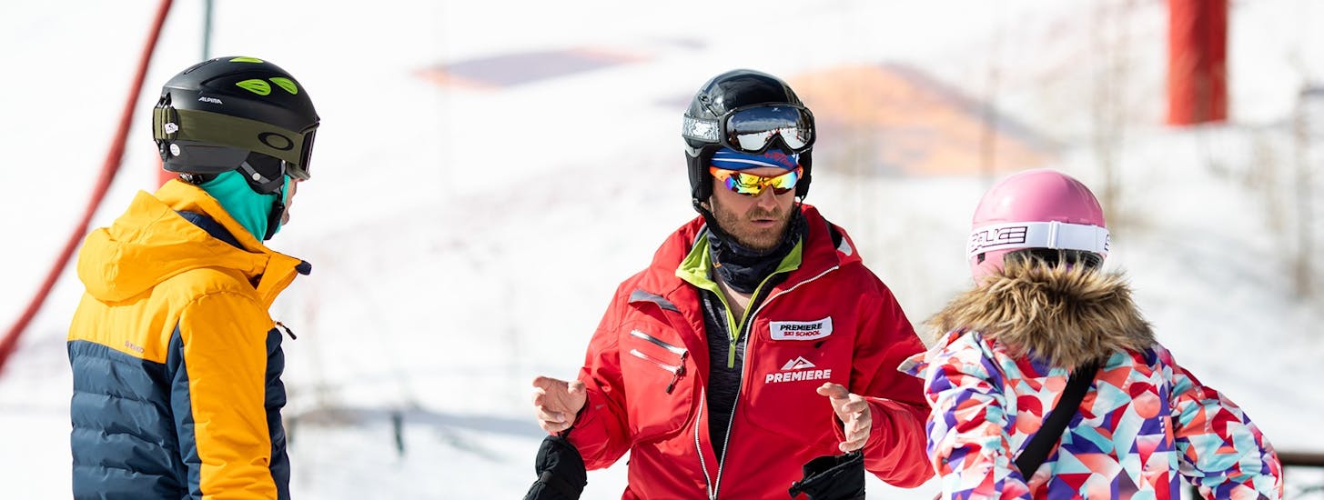 Ein Skilehrer gibt Ratschläge während des Snowboard-Privatunterrichts für Kinder und Erwachsene aller Levels mit der Premiere Ski School Vysoké Tatry.