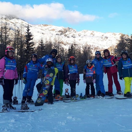 Kinder und Snowboardlehrer glücklich in Valmalenco nach einem der Snowboardkurse für Anfänger - Ferienkurse.
