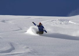 Un snowboarder desciende por las laderas durante las clases de snowboard para adolescentes de todos los niveles, con la escuela de esquí Neustift Olympia en el glaciar Stubai.