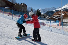 Een instructeur helpt een leerling tijdens de privélessen snowboarden voor kinderen en volwassenen van alle niveaus van de Zwitserse Skischool Wengen.