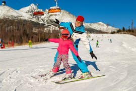 During the Ski Instructor Private for Kids (from 4 years), a little girl is having fun while learning how to ski under the supervision of an instructor from the ski school Ternavski Snow Academy Tatranska Lomnica.
