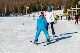 During the Ski Instructor Private for Adults - All Levels, an adult is taking the first steps on ski with the help of an experienced ski instructor from the ski school Ternavski Snow Academy Tatranska Lomnica.