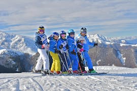 Kinderen en skileraar hebben plezier tijdens de Kinder Skilessen (4-12 jaar) - Kerstmis van de ski- en snowboardschool Scuola di Sci e Snowboard Prato Nevoso.